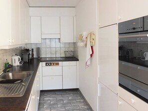A compact kitchen with white cabinets, a dishwasher, and a built-in oven. - Dorfstrasse 53a / 2 Appartement/Fewo 6-Bettwohnung by Interhome (Engelberg)
