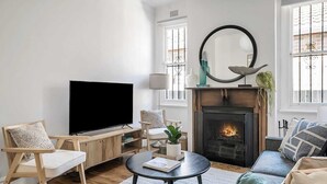 A living room with a fireplace, a television, and seating.