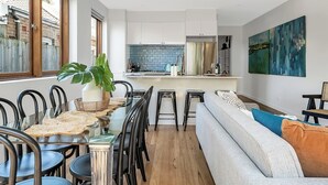 A modern kitchen with white cabinets, a blue backsplash, and a central island.