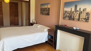 Ein Hotelzimmer mit Bett, Nachttisch, Wand-Fernseher und Kamin.