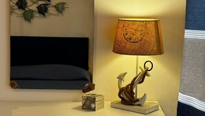 A bedside table with a lamp, a mirror, and a small decorative item.