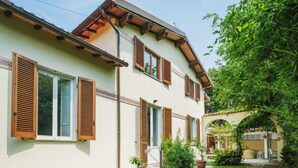 Ein zweistöckiges Haus mit Holzhörnern, einem Ziegeldach und einem Garten mit Topfpflanzen.
