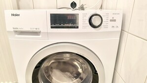 Une machine à laver Haier dotée d’un moteur à variateur de vitesse, d’un écran numérique et de diverses options de réglage.