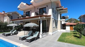 A modern two-story house with a swimming pool, outdoor seating, and a well-maintained garden. - BRAND NEW BEAUTIFUL 5 BEDROOM VILLA WITH PRIVATE GARDEN AND POOL IN GULPINAR!!!! (Dalyan)
