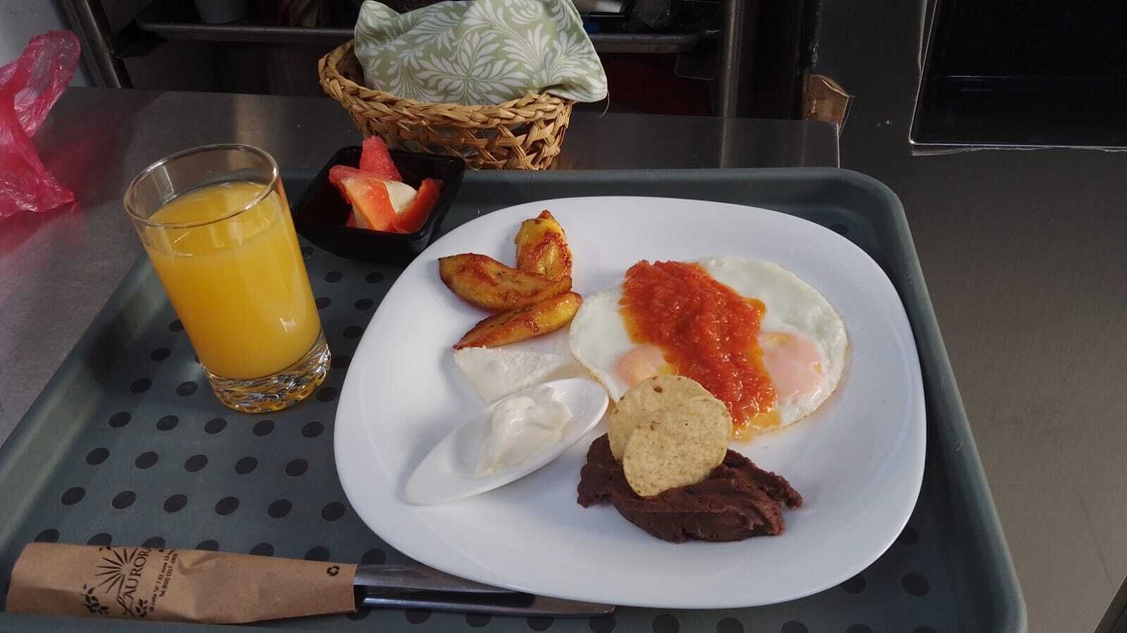 Ein Frühstücksbrett mit Eiern, Toast und einem Glas Orangensaft.