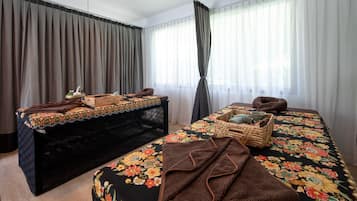 Relax in this serene spa room with a large bed, a matching bench, and a woven basket.