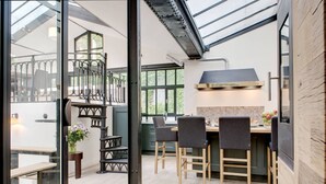 Una cocina moderna con comedor, una escalera y vistas a través de un ventanal.