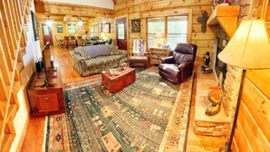 A log cabin interior with a cozy living room, a fireplace, and a dining area. - Gem in the Glades, secluded, minutes from Gatlinbu (Gatlinburg)