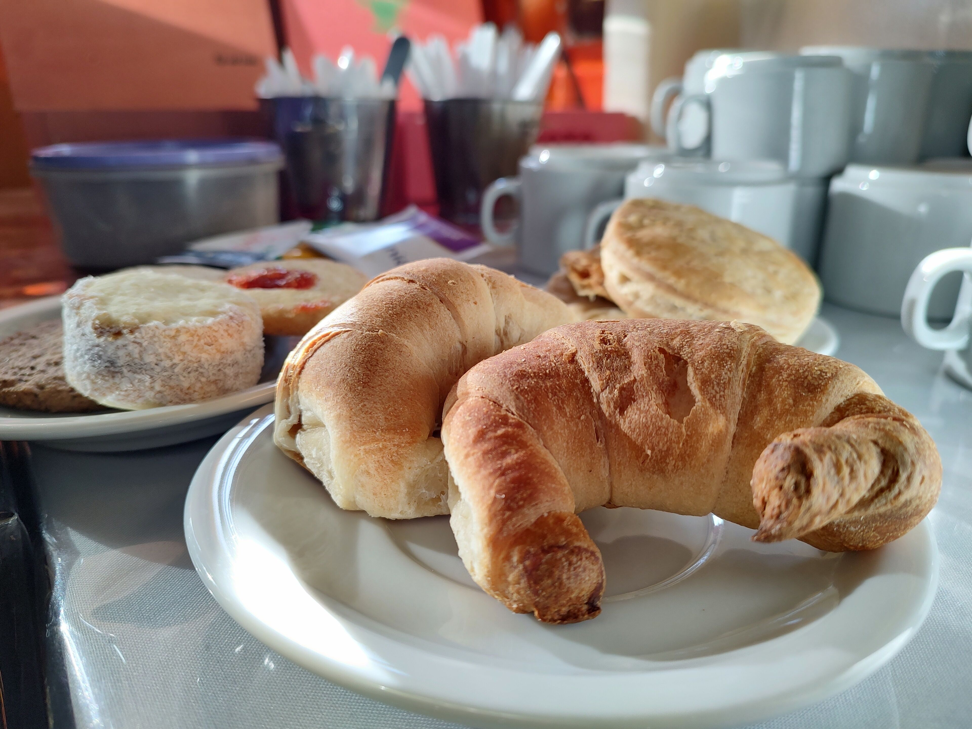 Ein Teller mit Croissants und einem Gebäck auf einem Tisch.