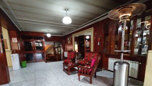 Un vestíbulo con piso de mármol, muebles de madera y un radiador.