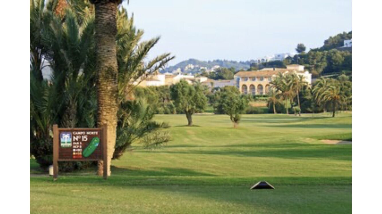 A golf course with a sign indicating hole number 15.