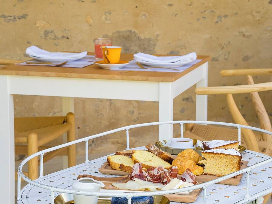 A breakfast setup with bread, pastries, and a drink on a metal tray.