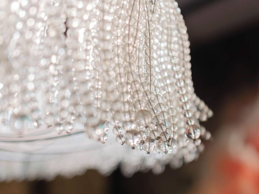 A close-up of a chandelier with multiple strands of clear, sparkling beads.