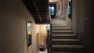 A staircase with a wooden ceiling and a view of a room with a window.