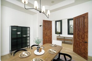 A dining area with a wooden table, black metal cabinet, and a plant centerpiece. - Mesa Luxury Home | Sleeps 14 | Heated Spa + Game Garage (Mesa)