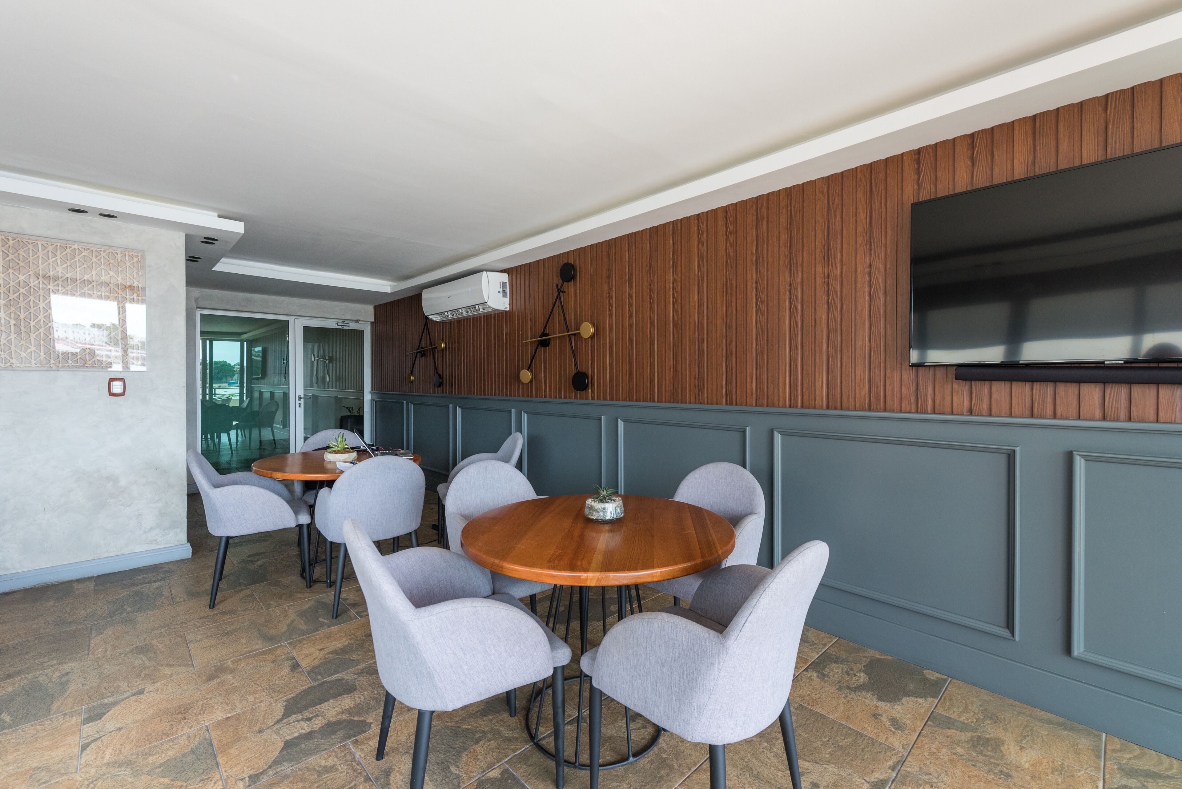 Un comedor moderno con una mesa redonda de madera y sillas tapizadas en gris.
