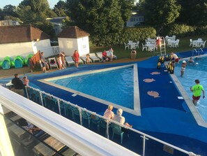 Area piscina con lettini e posto di salvataggio.