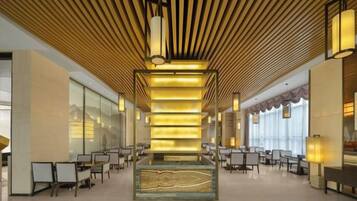 A spacious lobby with a central column, seating arrangements, and a modern ceiling design.
