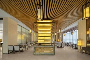 A spacious lobby with a central column, seating arrangements, and a modern ceiling design. - Fortune Sunshine Hotel (Tianshui)