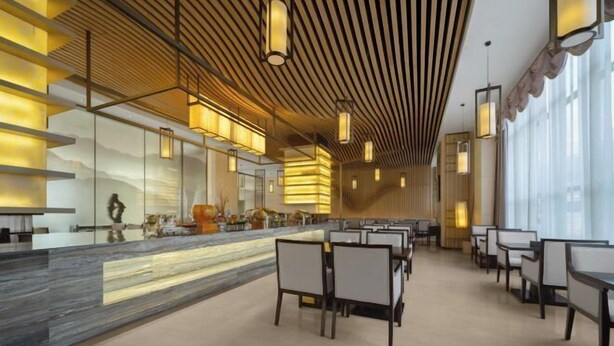A modern hotel lobby with a reception desk, seating area, and large windows. - Fortune Sunshine Hotel (Tianshui)