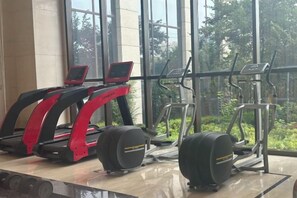 A gym with treadmills, elliptical machines, and exercise bikes. - Fortune Sunshine Hotel (Tianshui)
