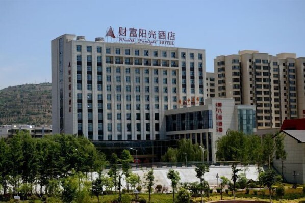 A multi-story hotel with a modern design, featuring a prominent signage at the top.