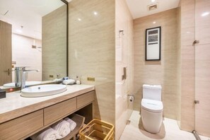 Un bany modern amb un mirall gran, un lavabo, un vàter i una zona de dutxa.