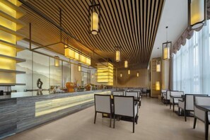 A modern interior with a long counter, seating area, and large windows.