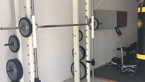 A weightlifting area with a squat rack, barbell, and weight plates. - Four - Miguel Apartment with panoramic view, among olive trees, sea 15 km away (Villa Viani)