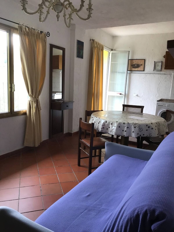 Un coin repas avec une table, des chaises et un lave-linge.