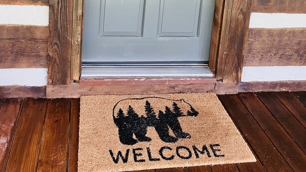 A wooden door with a frosted glass panel, a keypad lock, and a doormat with a bear silhouette and the word "WELCOME". - Well maintained cabin bordering national forest, close to Augusta, GA - -Masters (Edgefield)