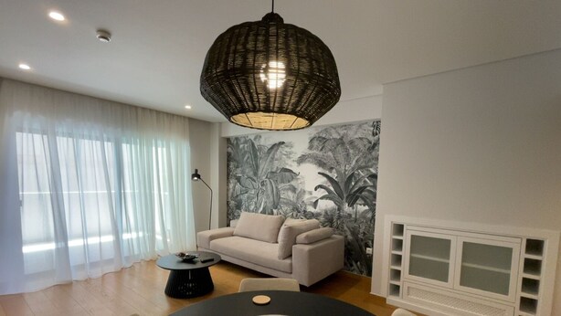 A modern living room with a round dining table, a sofa, and a large wall mural. - Athens Riviera 2-Bed Apt & Pool Access #Unoblu® (Alimos)