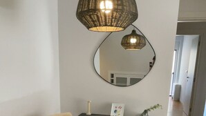 A round dining table with six chairs, a central woven placemat, and a large mirror on the wall. - Athens Riviera 2-Bed Apt & Pool Access #Unoblu® (Alimos)
