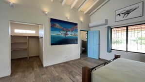 Een slaapkamer met een bed, een kledingkast, een schilderij en een raam met uitzicht.