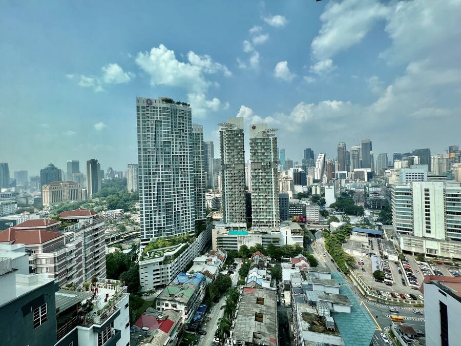A high-rise hotel with multiple floors, a rooftop garden, and a view of the cityscape.