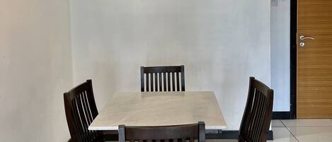 Un comedor con una mesa rectangular y cuatro sillas de madera.