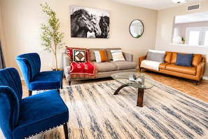 A living room with two sofas, a coffee table, and a large mirror.