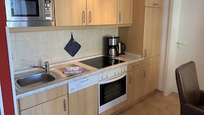 A compact kitchen with a microwave, coffee maker, and dishwasher.