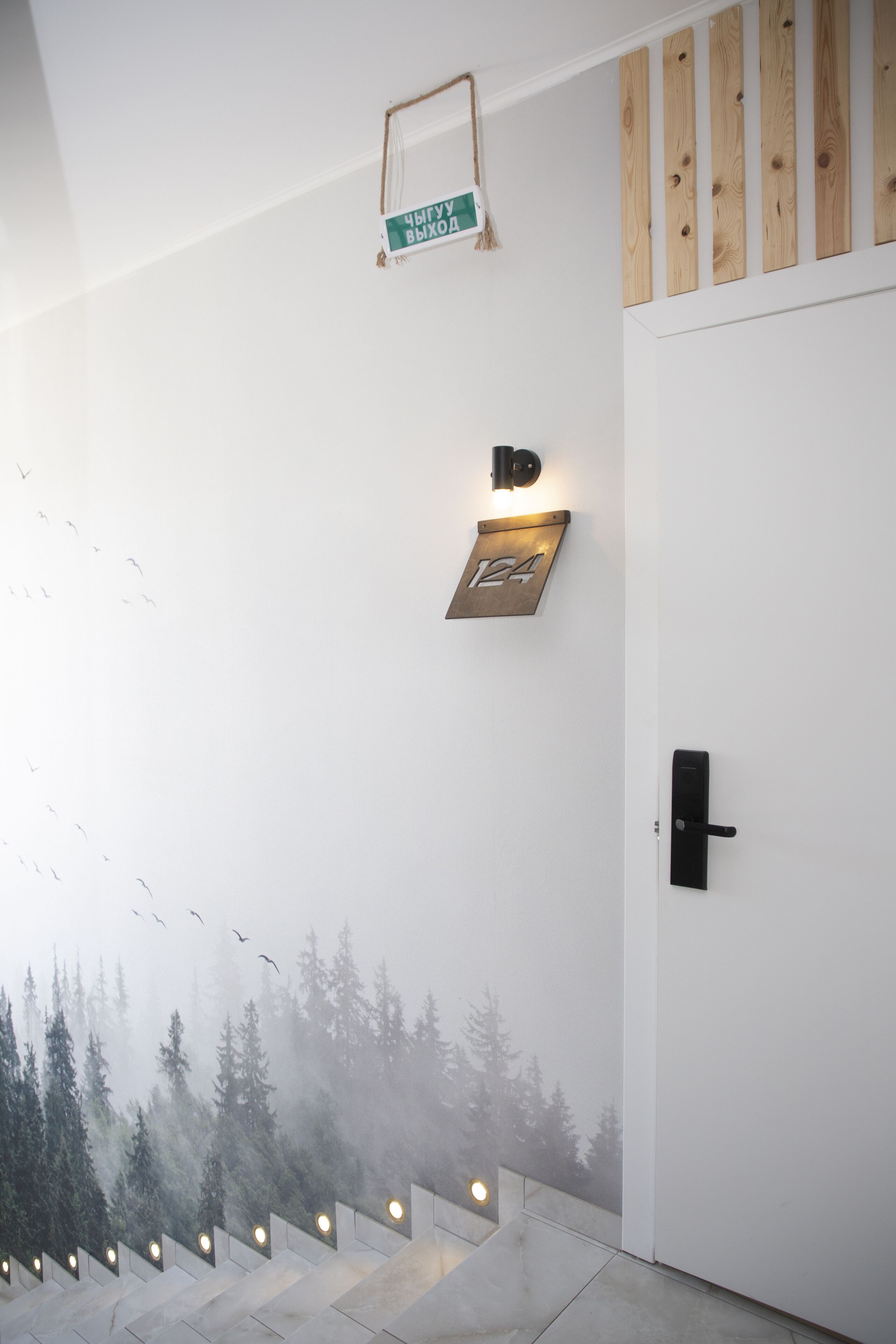 Un interior moderno con un panel de madera, un cartel con el número 124 y una puerta con pomo negro.