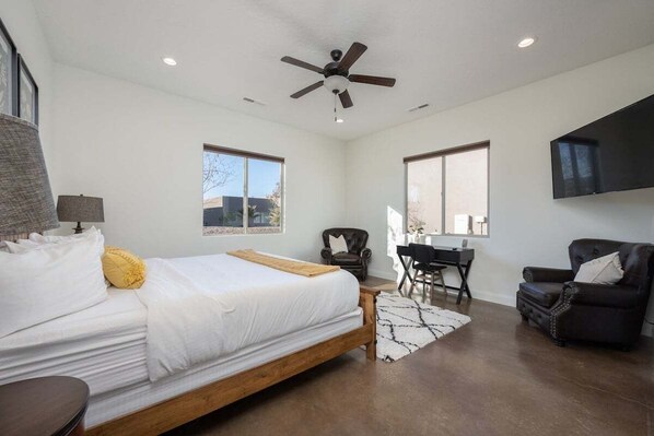 A bedroom with a bed, a desk, a chair, a ceiling fan, and a TV mounted on the wall. - Fairview: Pet Friendly + Resort Access + Golf (Hurricane)
