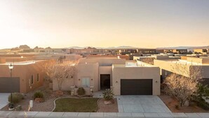 A residential area with modern houses, a clear sky, and distant mountains.