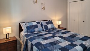 Une chambre à coucher avec un lit, des tables de chevet et une porte blanche.