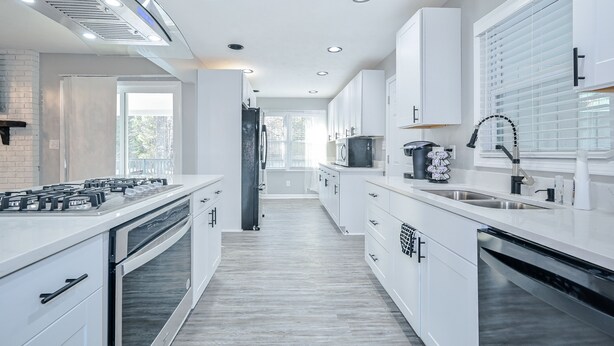A modern kitchen with white cabinets, stainless steel appliances, and a central island. - ***Spacious 4 Bedroom home w 1.1 acre backyard 10 mins Airport*** (atlanta)
