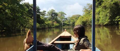 Explore the serene river landscape from this charming boat, featuring a bench seat and small table for a peaceful ride.