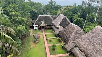 A traditional thatched-roof structure with a central open area and a pathway leading to it.