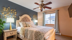 A bedroom with a bed, nightstands, a ceiling fan, and a window with curtains. - Home sweet home! (Missoula)