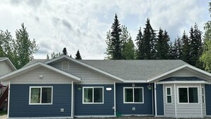 A two-story building with a gabled roof, multiple windows, and a small porch area. - Prime location, Aurora viewing, Fast WI-FI!! (Fairbanks)