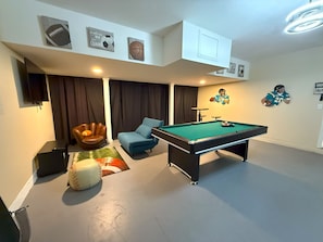 Relax in a sporty atmosphere with a pool table, comfortable seating, and entertainment options.