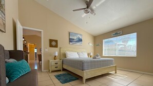 A bedroom with a bed, a nightstand, a ceiling fan, a window with blinds, and a door leading to another room. - Ultimate Heated Pool Retreat ★ Fire Pit + Game Room ★ Family Fun (Davenport)