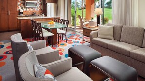 A modern kitchen with a microwave, refrigerator, and coffee maker. There is a dining area with a glass table and chairs, and a living room with a sofa and ottoman. - Marriott Shadow Ridge at Palm Desert, CA (Palm Desert)